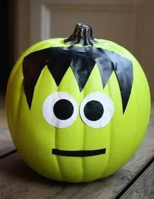 A no-carve pumpkin-painted all-green, with black duct tape, jagged edges, and textured layers, mimics this Frankenstein character's iconic square head and stitched look.