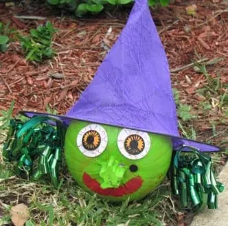 a purple witches hat, green curly bows and bloodshot sticker eyes make this dollar store pumpkin