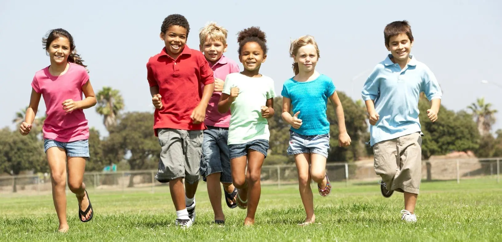 Group Of Children Running In Park
